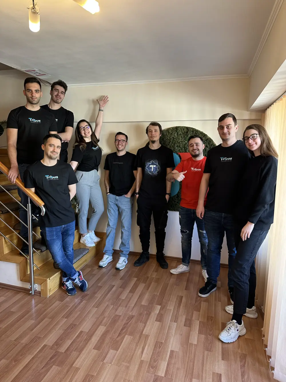 The whole Tribus team in branded tees on the studio stairs