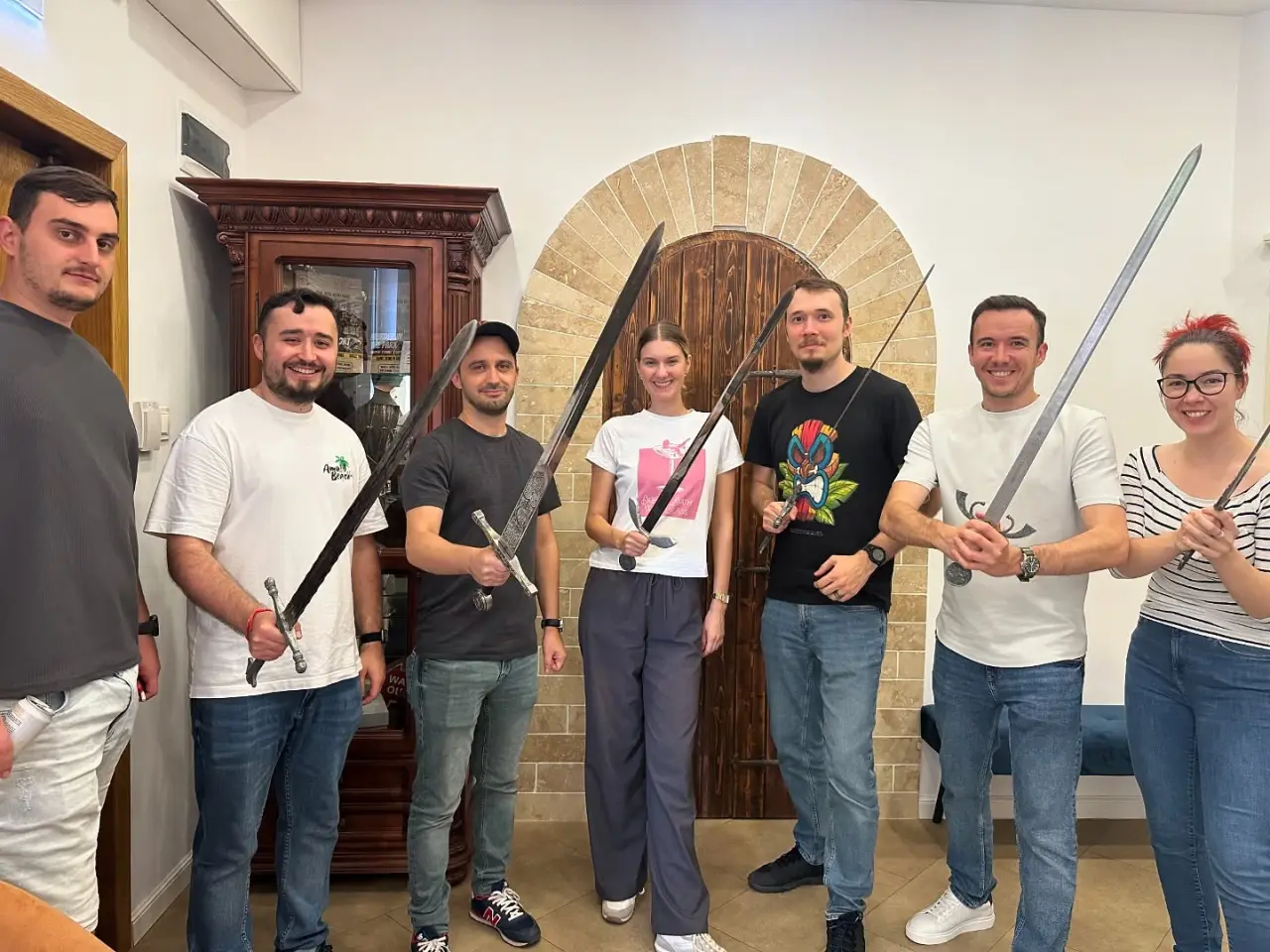 The Tribus team together on an off-site, swords in hand
